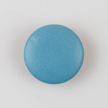 Guzik obciągany skórą naturalną w kolorze jasno niebieskim, śr. 38 mm
