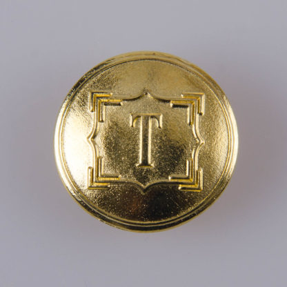 Guzik ozdobny z literką "T", ogólnego zastosowania o średnicy 22 mm, kolor złoty.