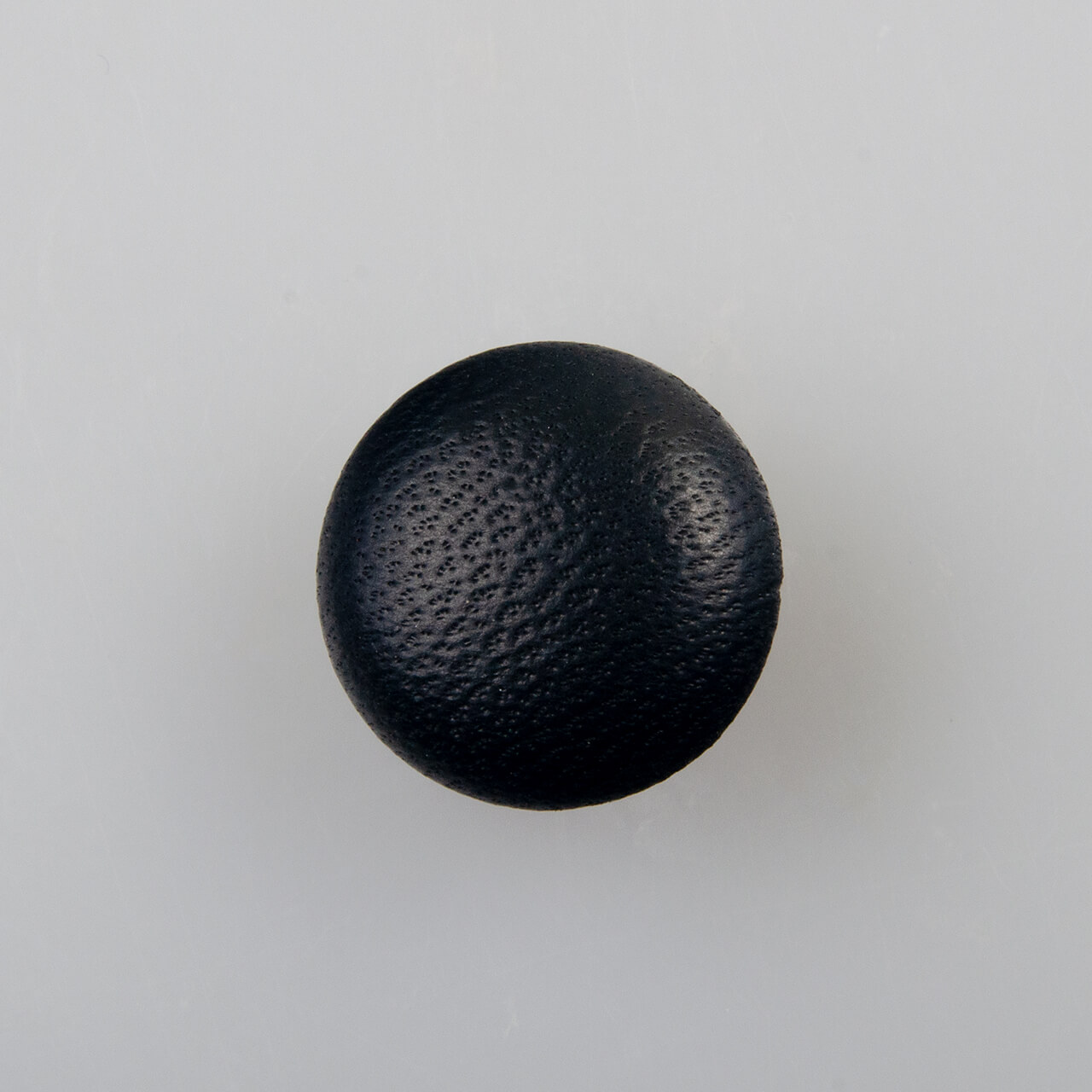 Guzik obciągany naturalną skórą w kolorze czarnym, śr. 15 mm