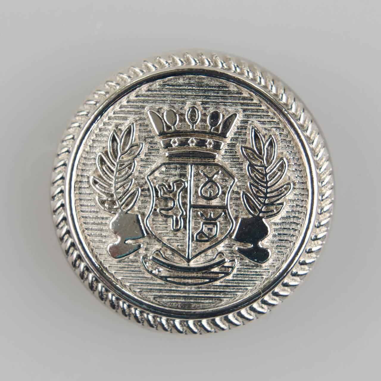Guzik ozdobny z herbem ogólnego zastosowania o średnicy 25 mm, kolor srebrny.